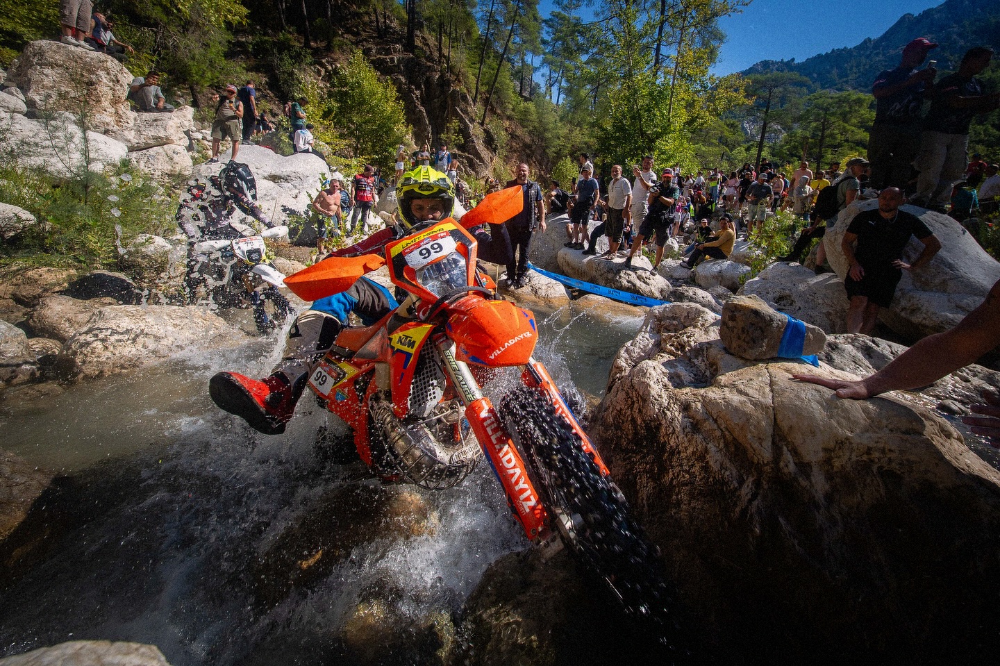 Enduro rider crossing a rocky stream